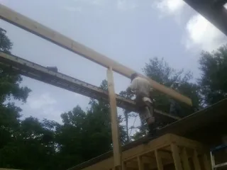 Carpenter setting a ridge beam over a new addition frame — Ice Dam Removal by Roofing Brothers in New Holland