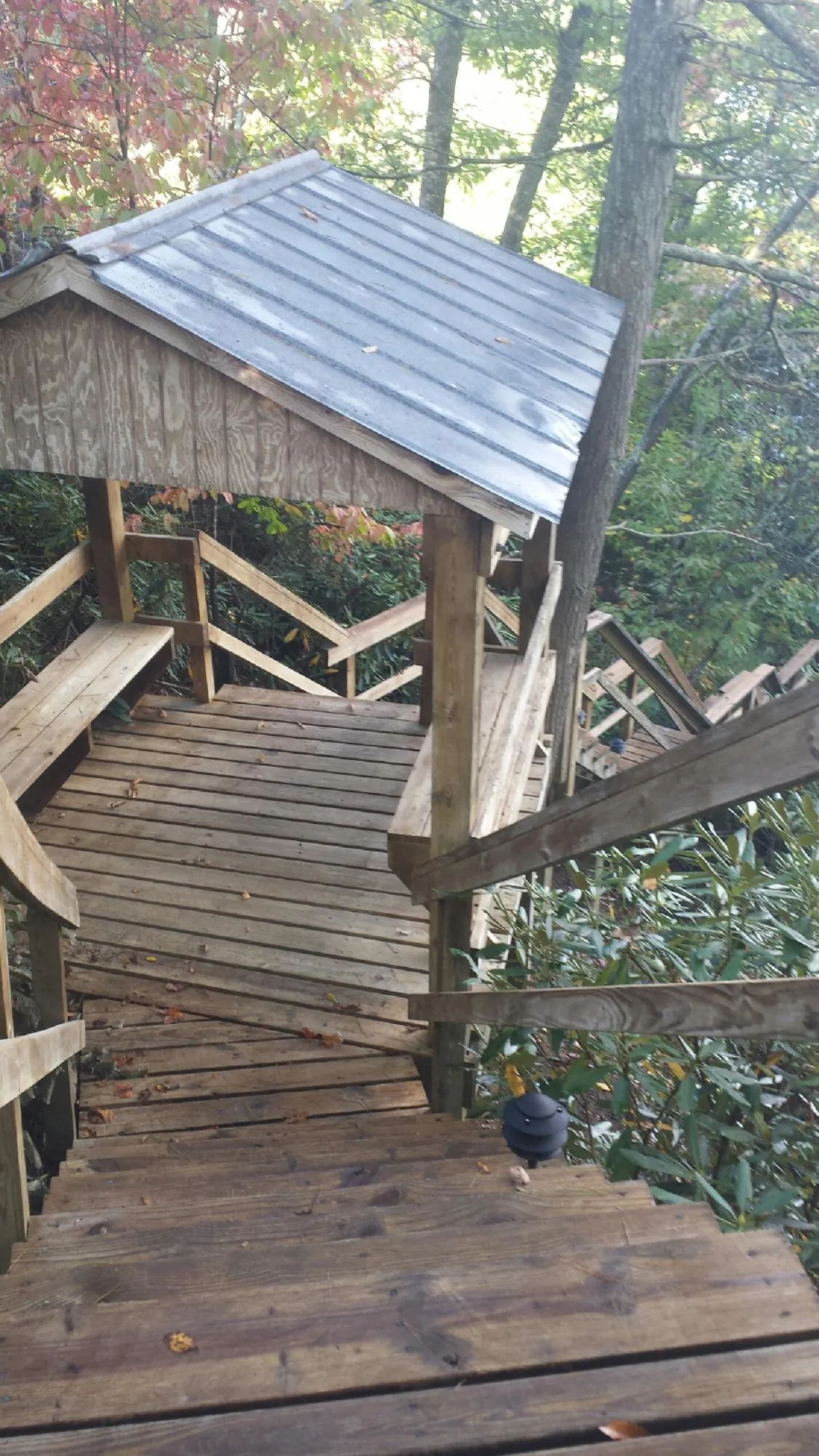Metal roofed shelter over wooden steps on a wooded walkway — Skylight Repair & Installation work by our crew in New Holland